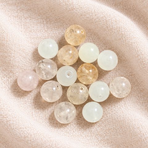 Clear round gemstones with hints of pink, gold and mint